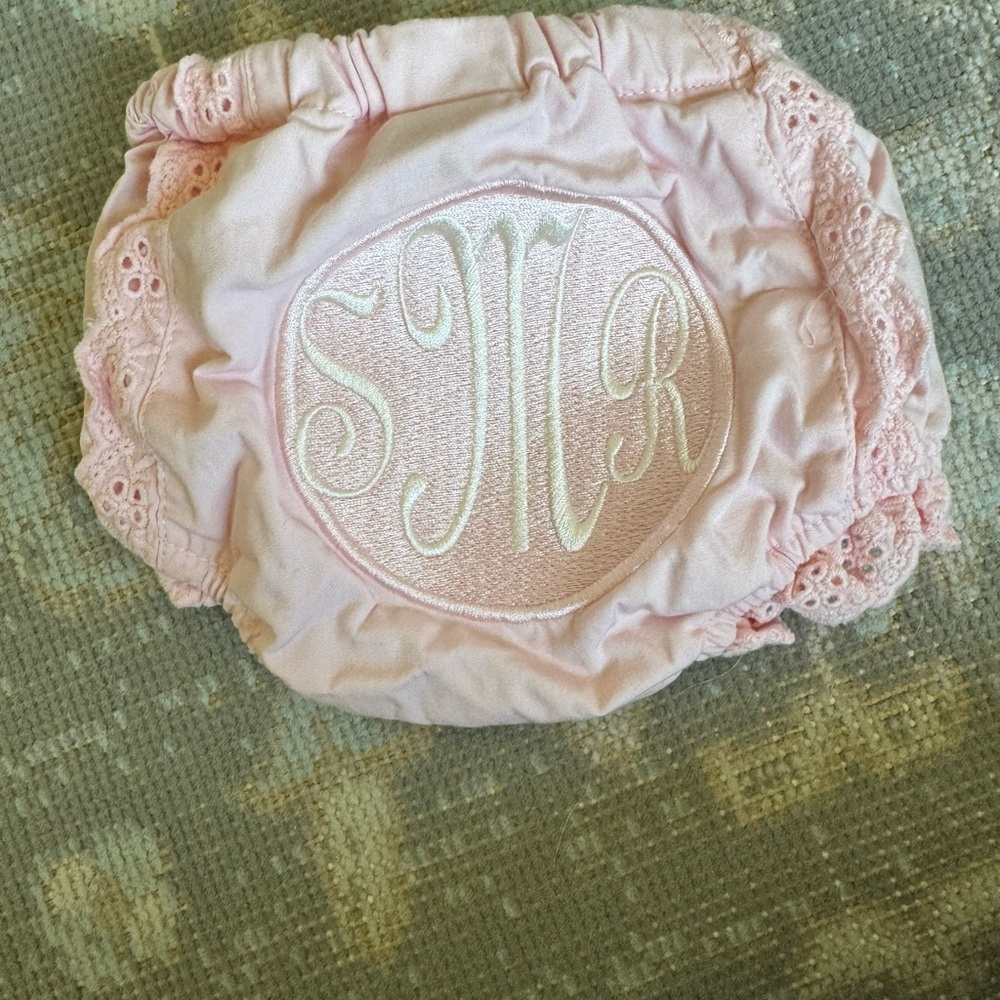 Pink newborn bloomers w/ ruffle eyelit trim, monogram “sMr” on booty.